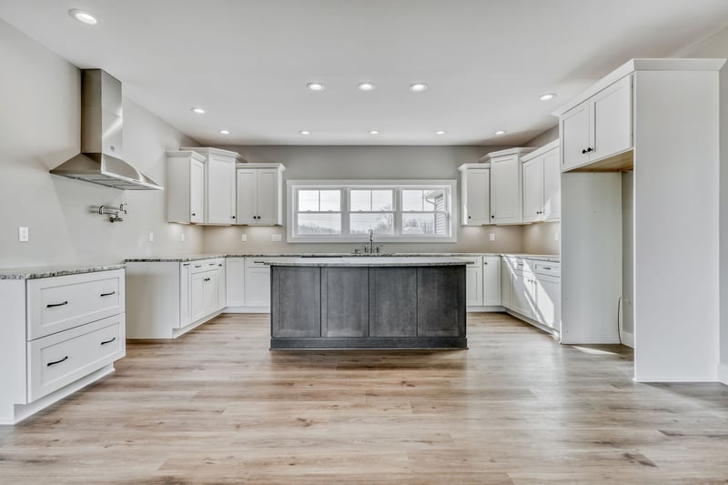 Single kitchen island with sink and white shaker cabinetry in new construction home by Gerber Homes
