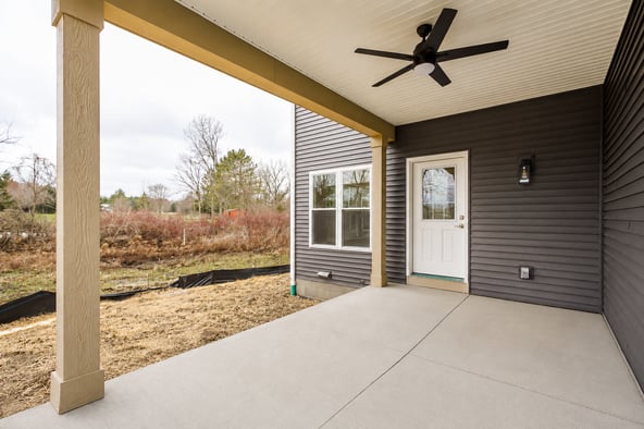 Covered backyard patio with a ceiling fan, exterior lighting, and access to the home.
