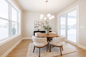 Greater Rochester dining room with round wood table, globe chandelier, sliding glass door, and black sideboard