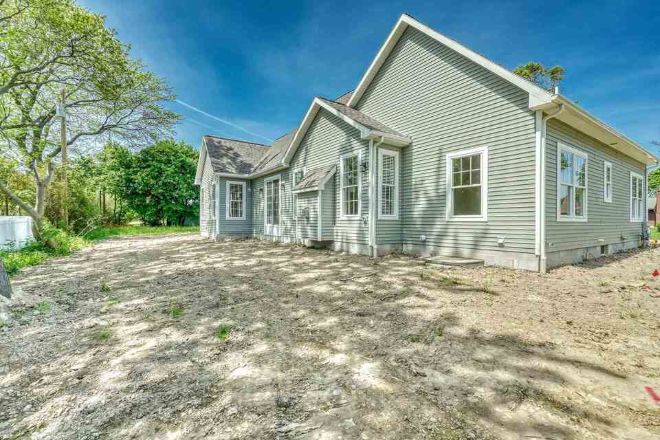 Custom Home Exterior With Light Green Siding by Gerber Homes