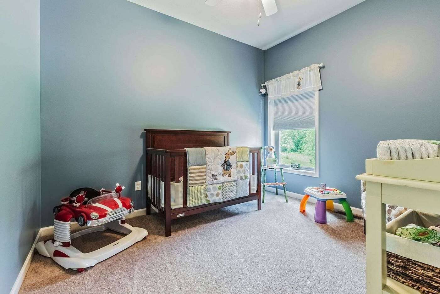 Custom secondary bedroom with crib and children's toys near Rochester, NY