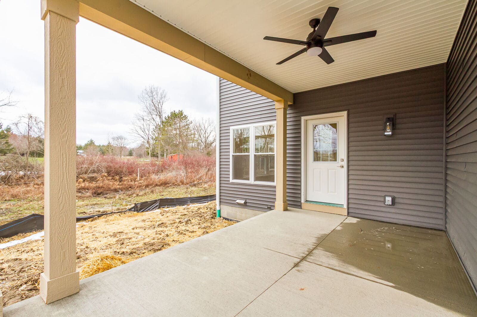 Covered backyard patio with a ceiling fan, exterior lighting, and access to the home.