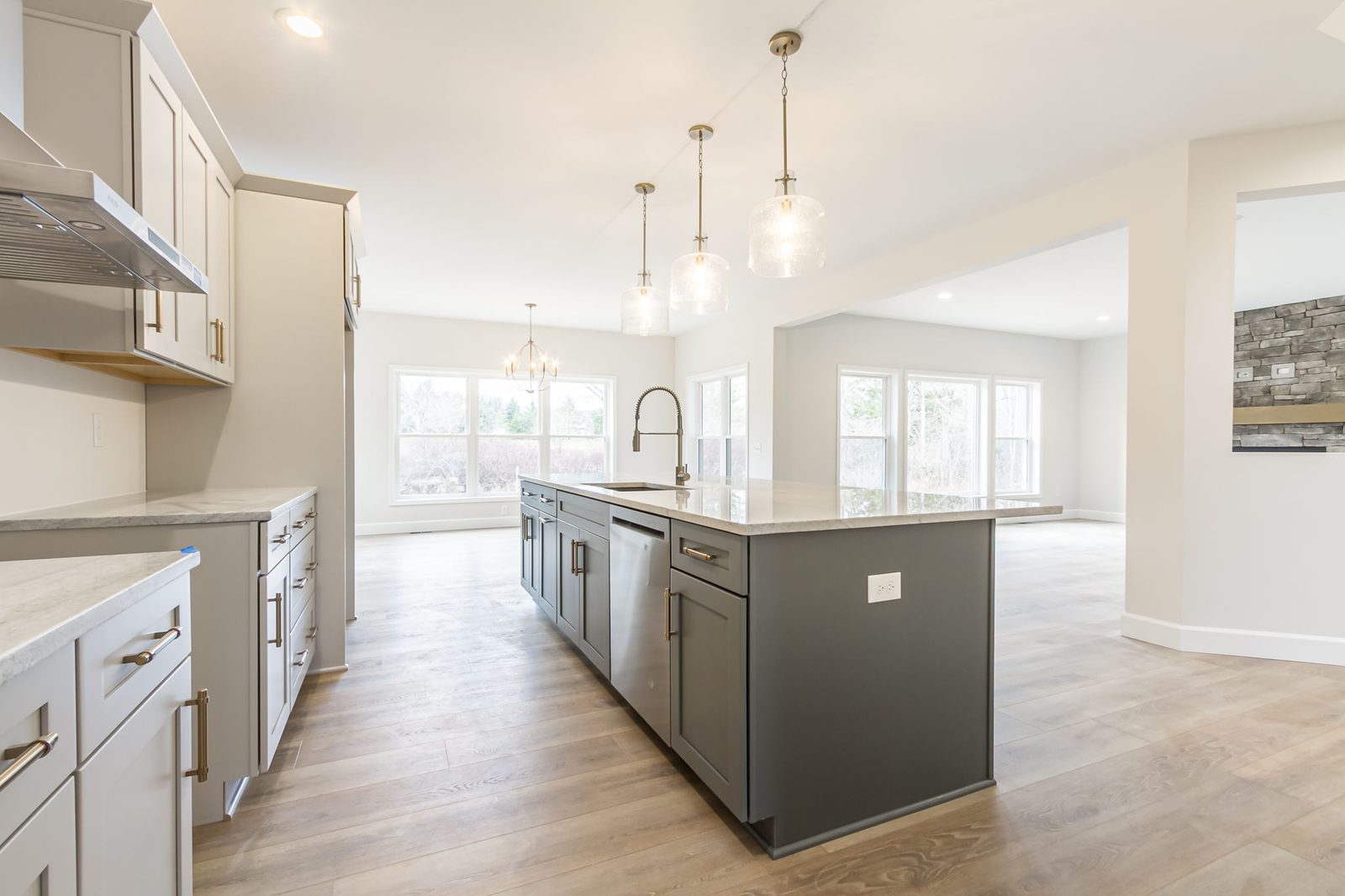 Kitchen island with dishwasher and view toward dining area windows