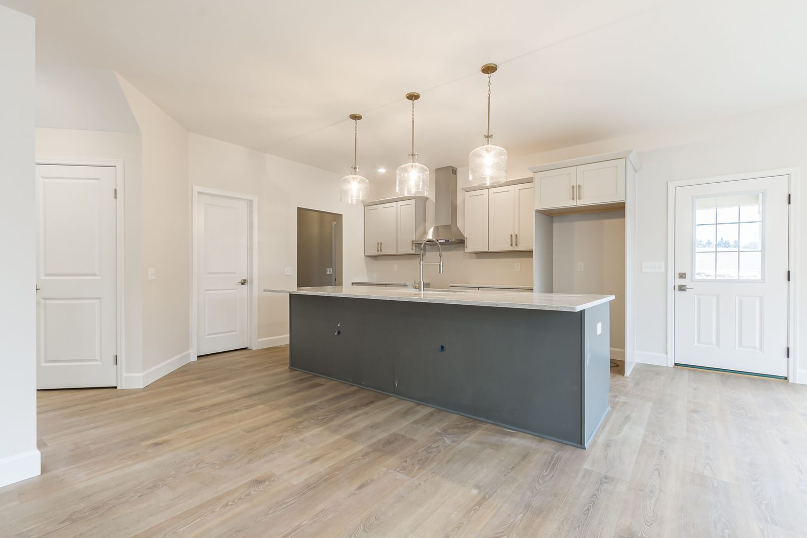 Kitchen island with hallway and back door leading to yard