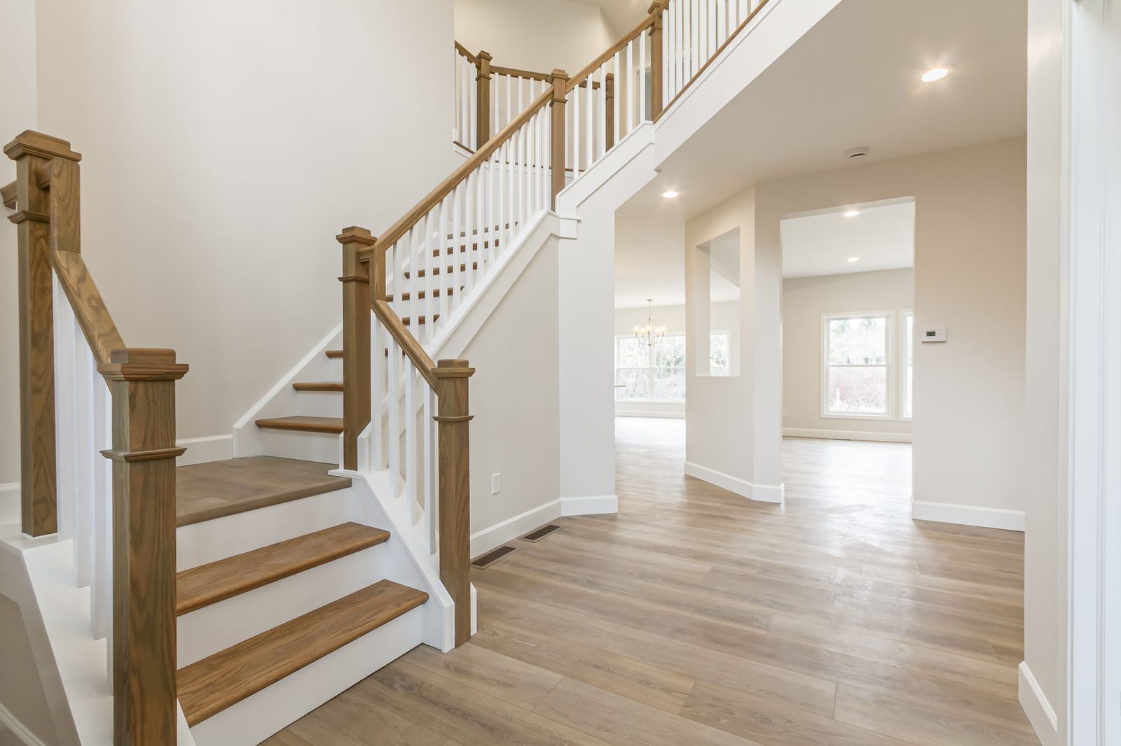 Staircase with wood railings overlooking open living area below