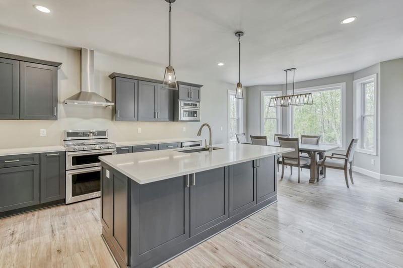 Kitchen in greater Rochester luxury custom home with gray shaker cabinetry and stainless steel appliances