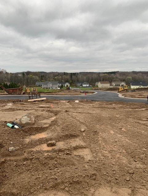 Raw land with view of paved road in back on cloudy day for new home construction in Walworth, NY