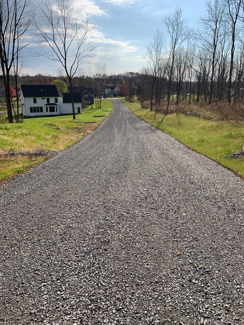 Road down Scout Path new home community on sunny day