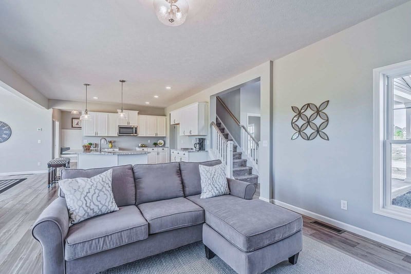 Open-concept kitchen and living room area with recessed and pendant lighting