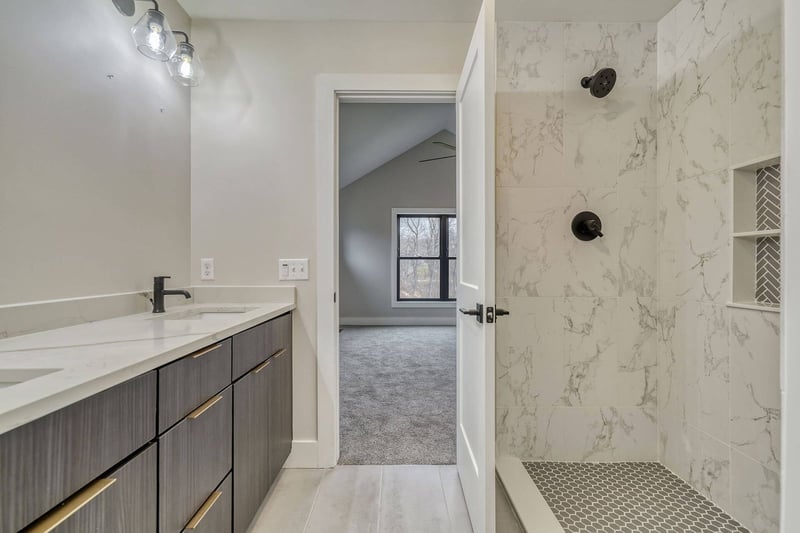 Luxury walk-in shower and double vanity with custom shelving in shower