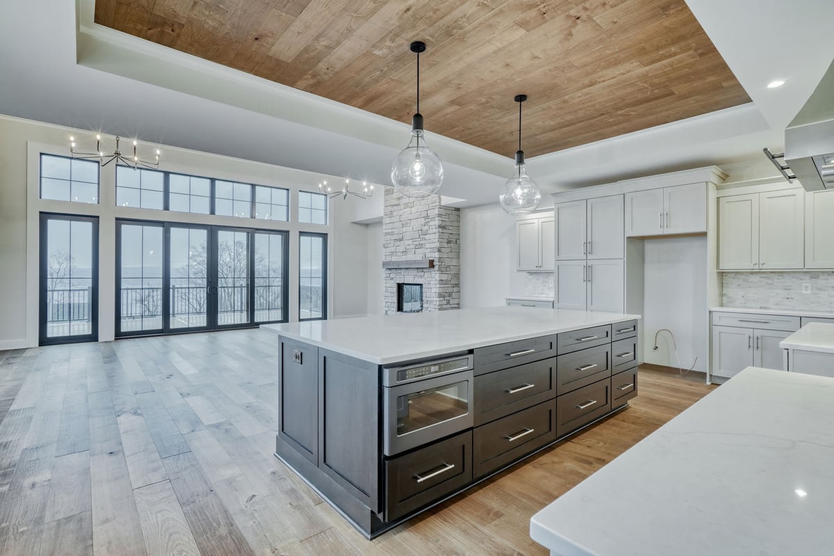 Two glass pendant lights above kitchen island in new construction home by Gerber Homes