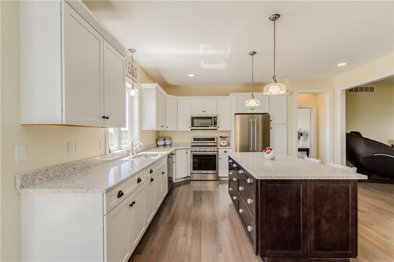 View of kitchen in custom home with expansive storage in white shaker cabinets