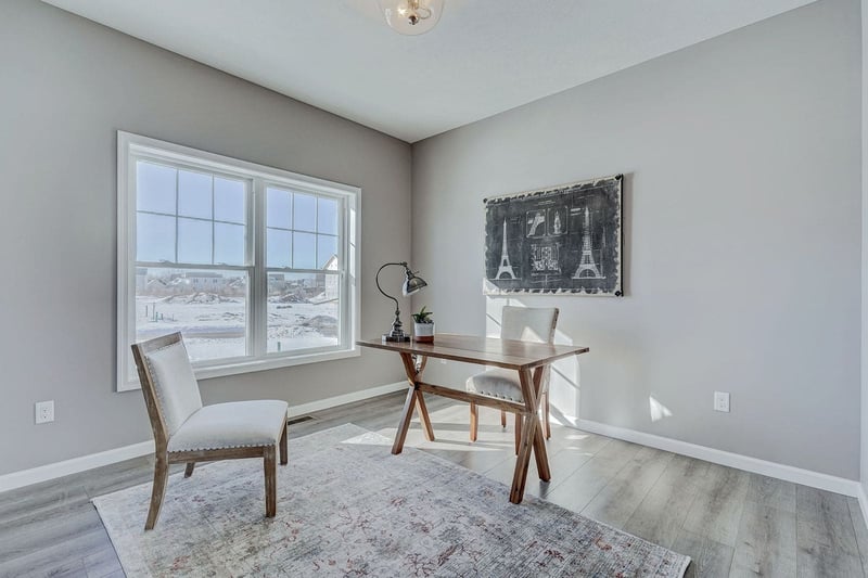 Custom home office with desk and two chairs by window
