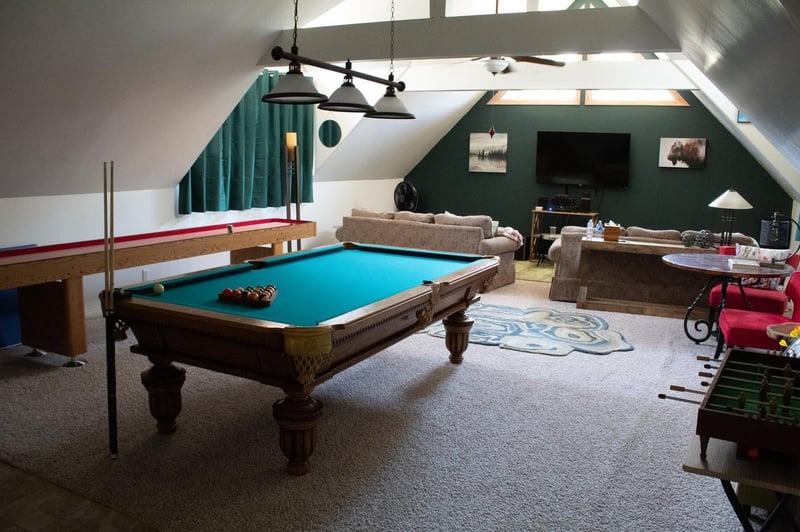game room with pool table foosball and couches with tv in Rochester area home