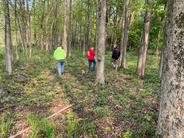 Gerber Homes team walking through trees for custom home building on Drumlin Drive