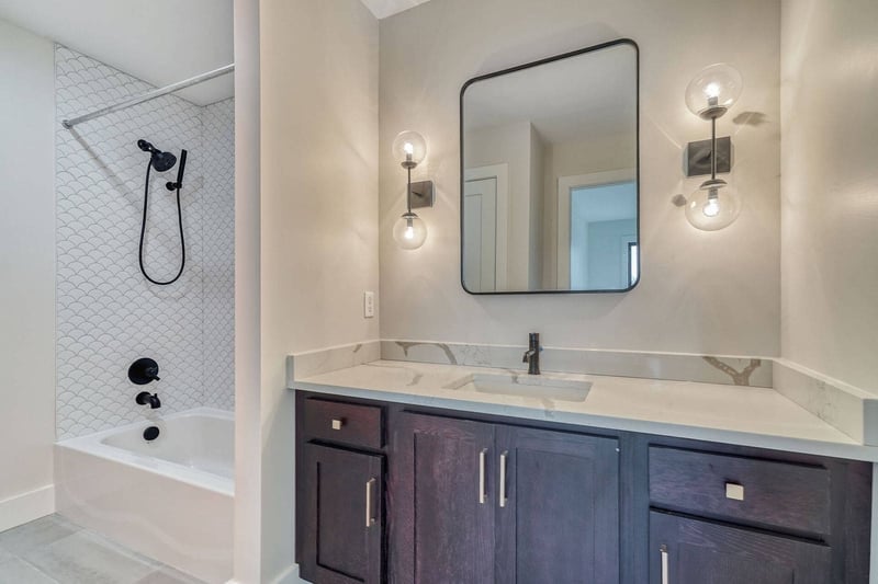 Shower tub combo with matte black fixtures and vanity