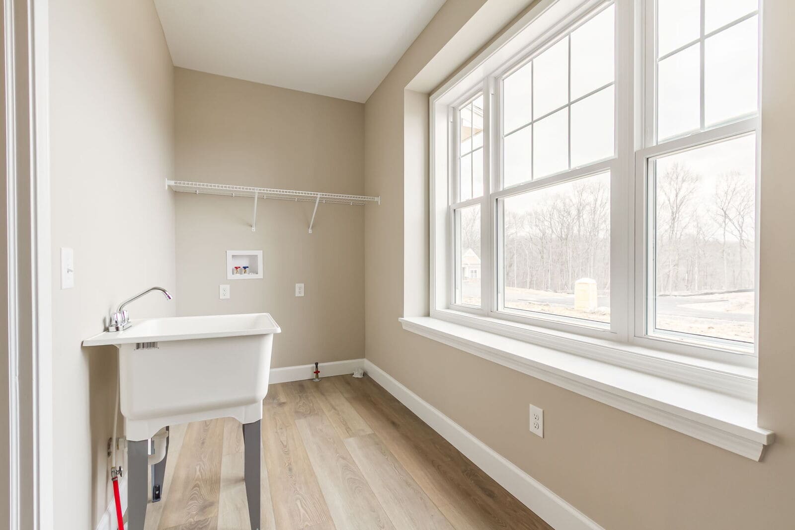 Laundry room with utility sink and large windows
