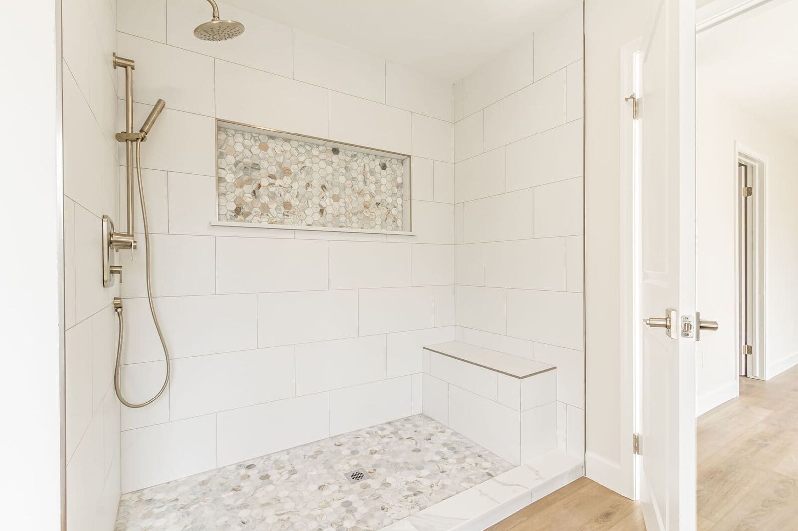 Walk-in tiled shower with built-in bench and multiple shower fixtures