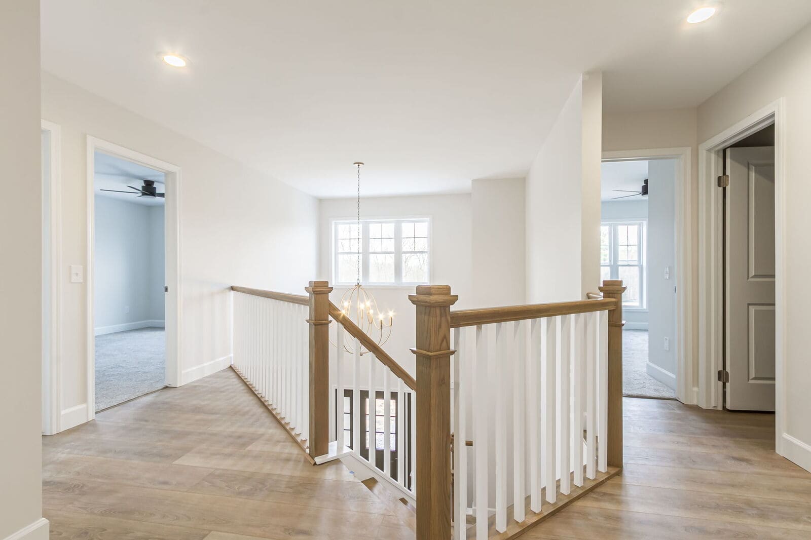 Open upstairs landing with wood flooring and white railings