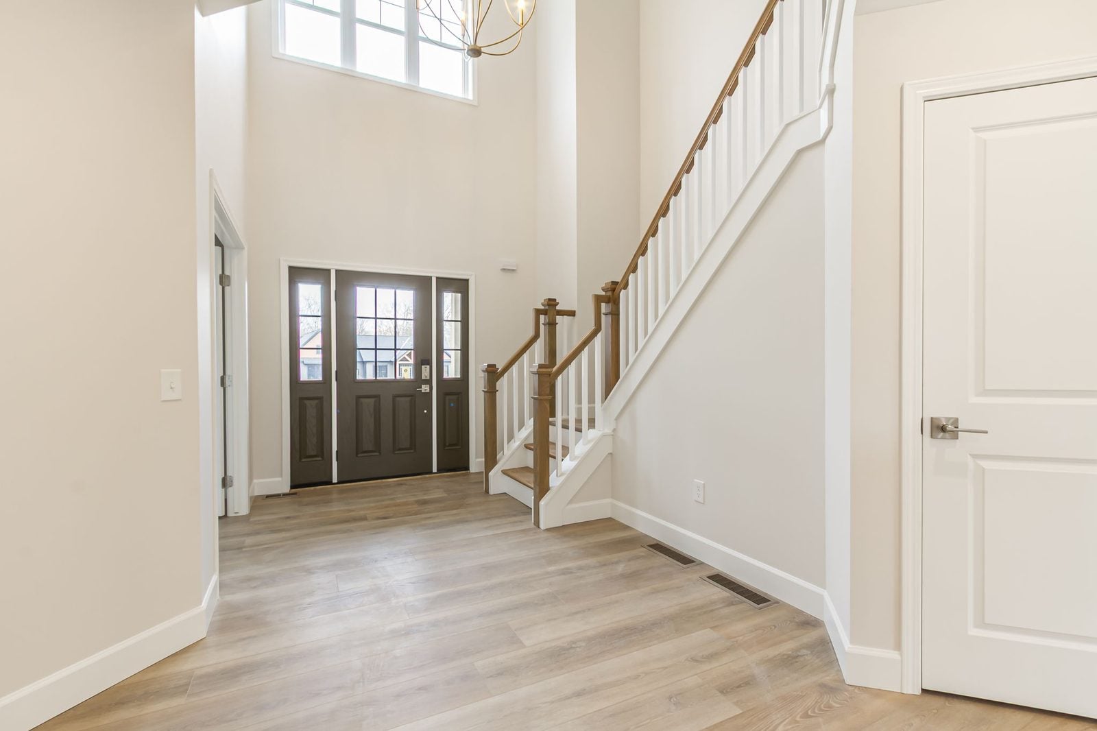 Two-story foyer with wood staircase and white balusters