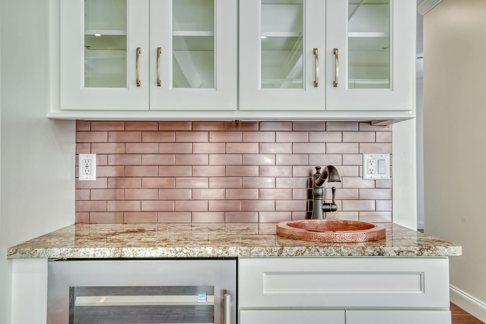 Wet bar with copper sink, metallic subway tile backsplash, glass-front cabinetry, and beverage refrigerator